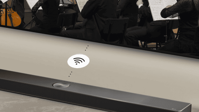 Barra de sonido negra bajo un televisor con músicos orquestales y un icono de wifi.