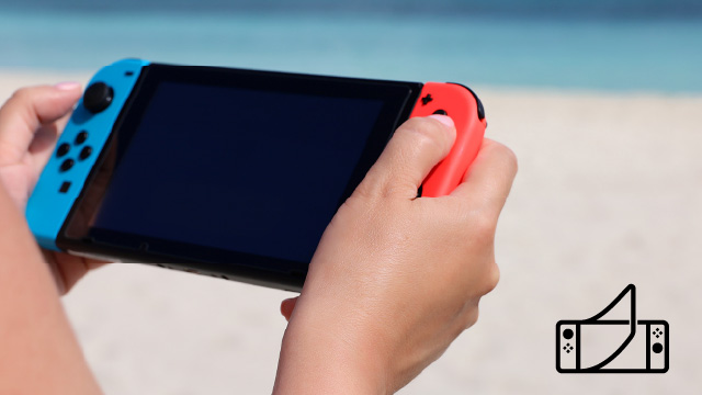 manos sosteniendo una nintendo switch con una playa de fondo