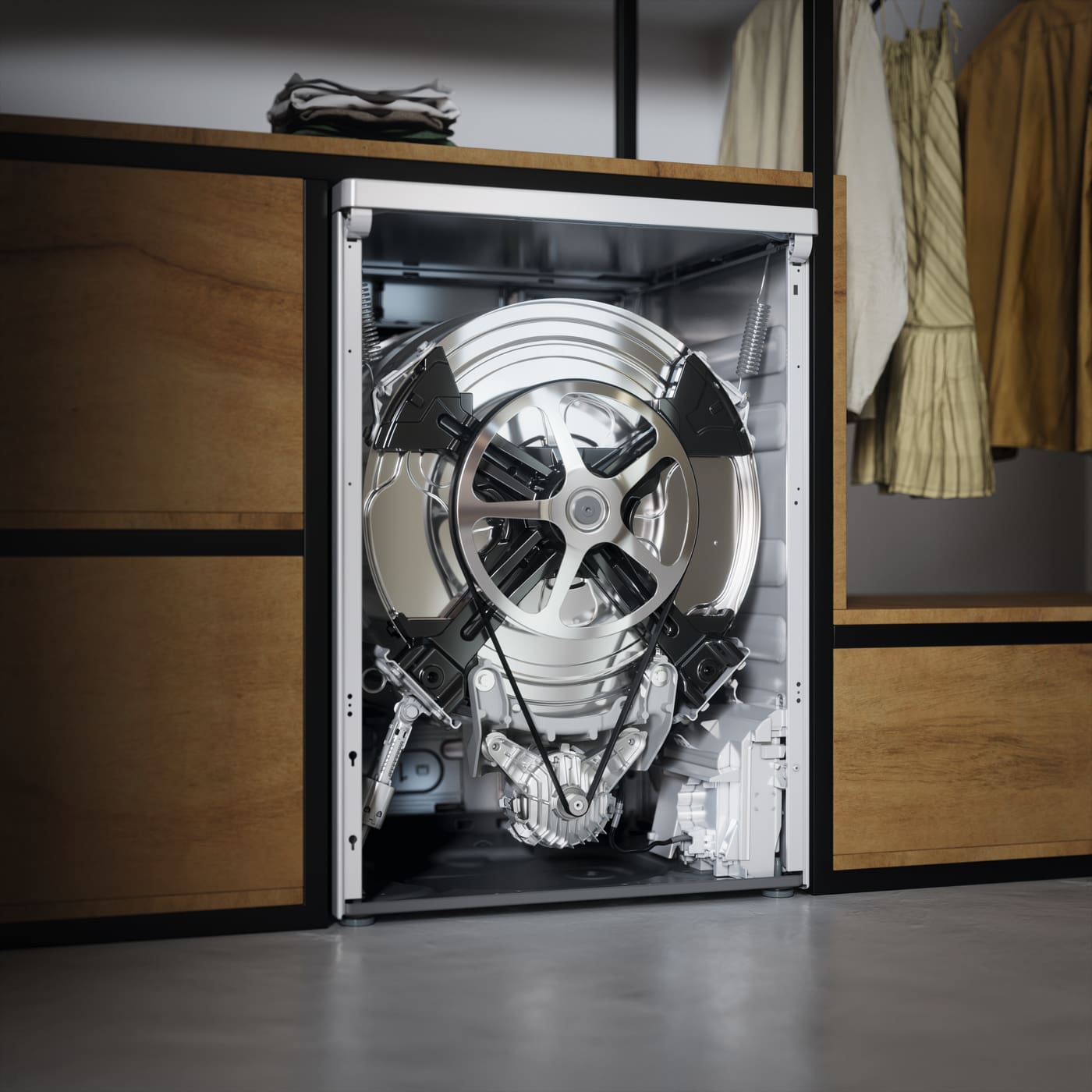 Interior de lavadora con tambor metálico expuesto, dentro de un armario de madera con ropa colgada y doblada encima.