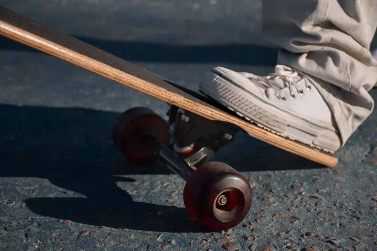 Pie sobre un skate eléctrico sobre asfalto.