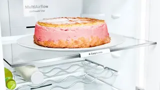 Detalle de los estantes de cristal del refrigerador, con una de las bandejas easy access extendida para poder extraer fácilmente una gran tarta