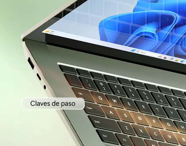 Portátil abierto mostrando el teclado negro y la pantalla con un fondo de pantalla azul abstracto. El texto "Claves de paso" está superpuesto.