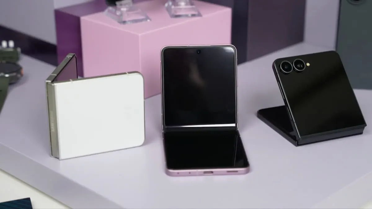 Tres smartphones plegables Samsung Galaxy Z Flip en colores blanco, rosa y negro sobre una superficie de exposición.