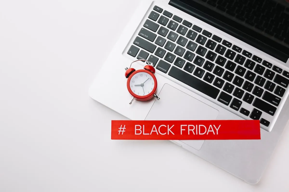 Ordenador portátil con reloj rojo y letrero de Black Friday.
