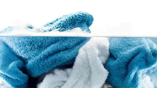 Tres toallas de colores azules y blancos en agua con jabón