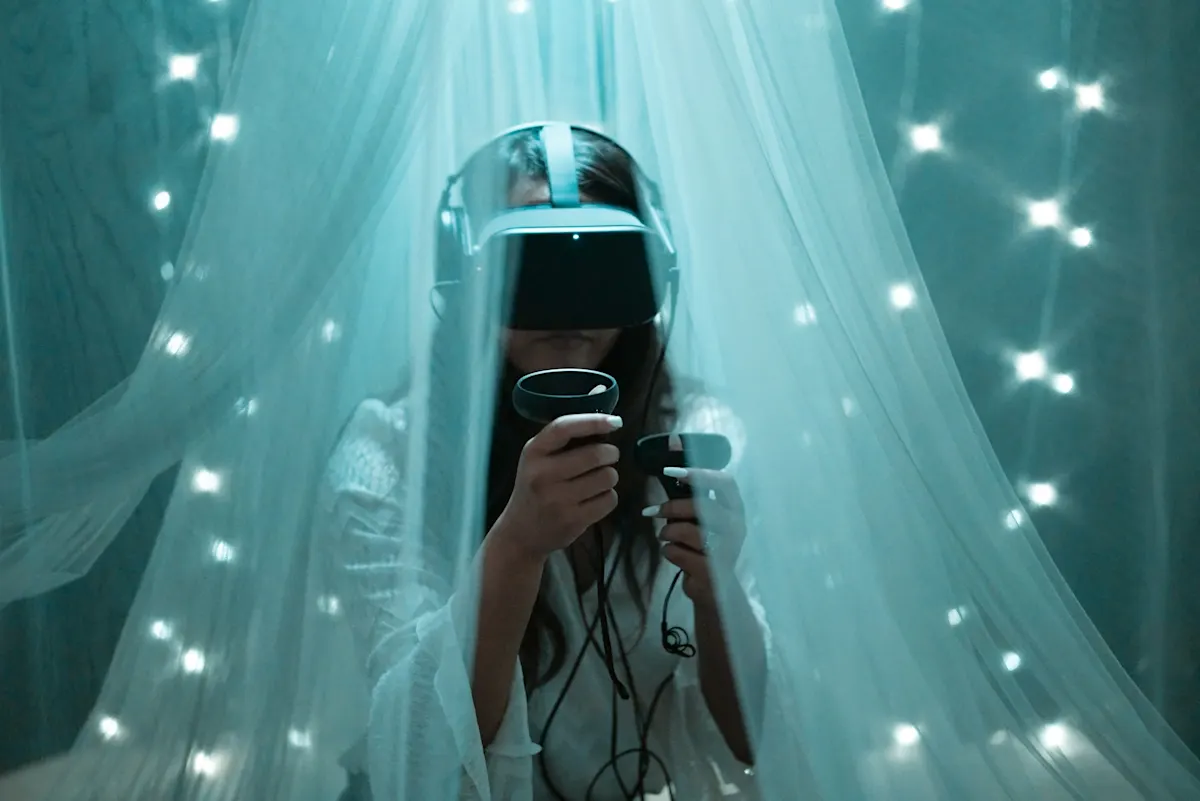 Mujer con gafas VR y mandos, vestida de blanco, bajo dosel con luces. Cables visibles. Fondo azulado.