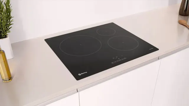 Imagen de la placa instalada sobre una encimera clara en una cocina con muebles blancos