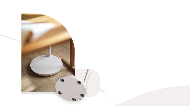 Base redonda blanca de lámpara bajo mueble de madera. Otra base blanca con tornillos visibles está en el suelo.