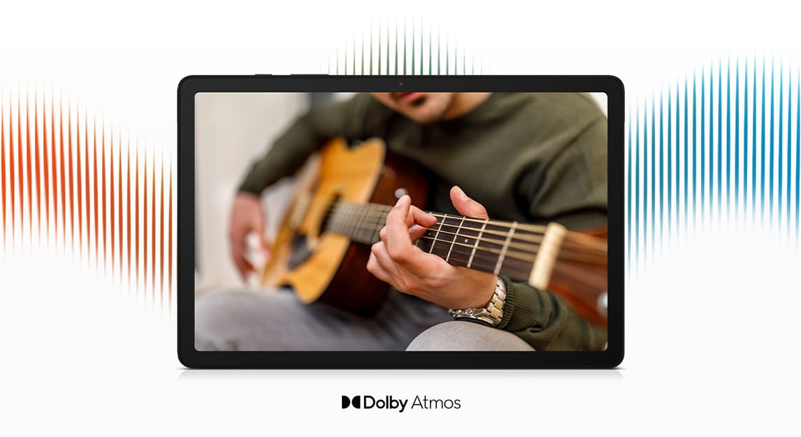 Tableta negra muestra persona tocando guitarra; lineas rojas, blancas y azules en fondo blanco. Logotipo Dolby Atmos al frente.