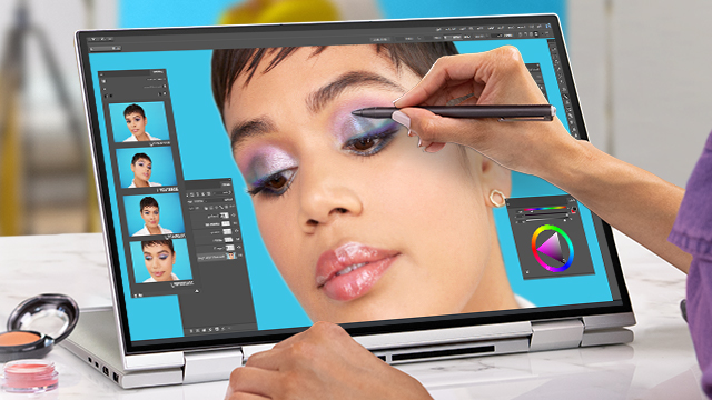 Laptop muestra retoque digital de maquillaje con lápiz óptico. Paleta de colores y fotos en pantalla. Cosméticos en la mesa.