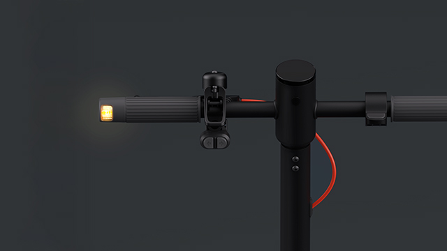 Detalle del manillar del patinete con luz LED encendida en el extremo izquierdo.