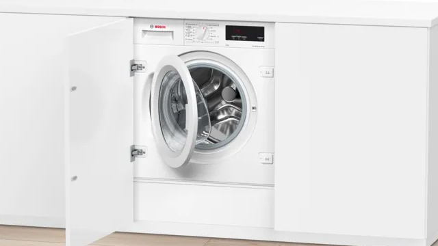 Secadora con bomba de calor, instalada en un amplio cuarto de lavado, junto a una estantería con ropa limpia y un cesto de ropa para lavar