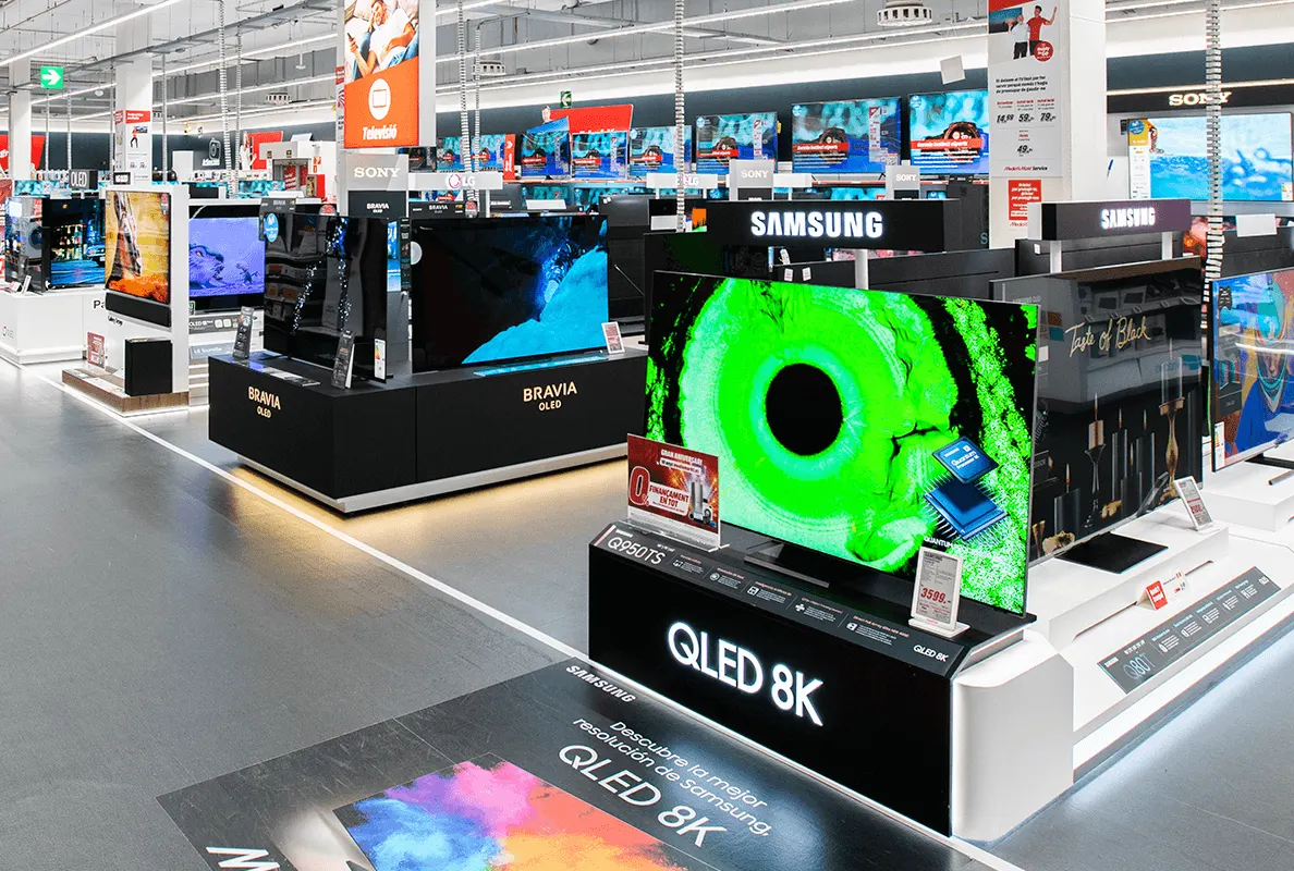 En una tienda se exhiben televisores de marcas como Sony y Samsung. Los televisores muestran imágenes variadas.