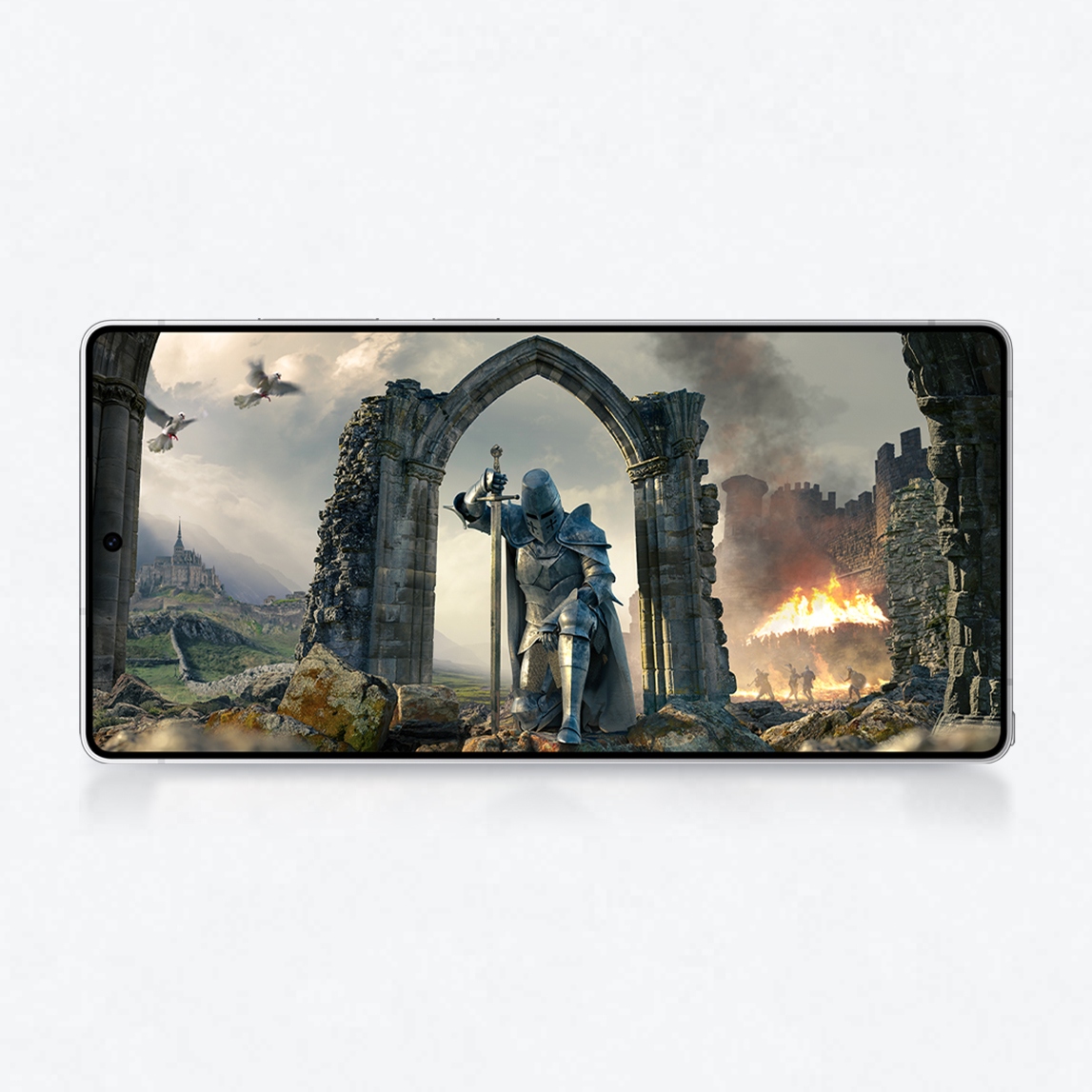 Un móvil muestra un caballero con armadura y espada ante un arco de piedra en ruinas, con castillo y fuego al fondo.