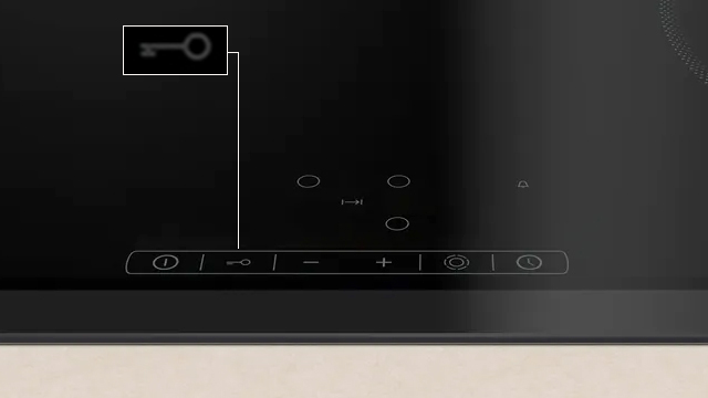 Detalle del símbolo "llave" en el control de la placa, que activa la función de seguridad para niños