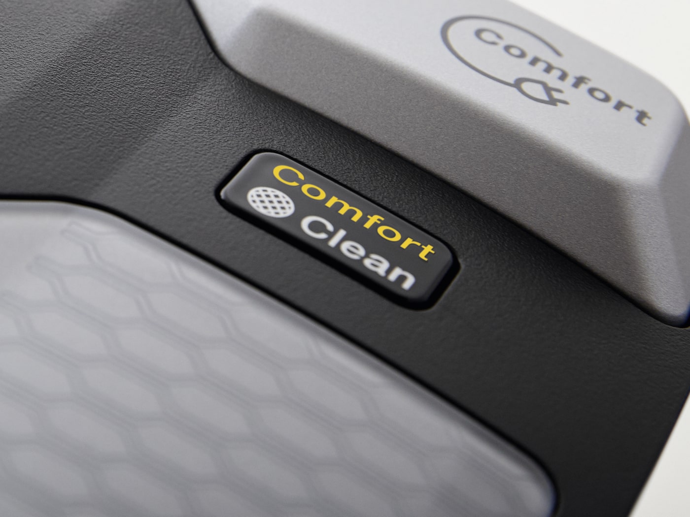 Primer plano de un dispositivo con botones grises y negros. Las palabras "Comfort Clean" aparecen en amarillo en un botón.