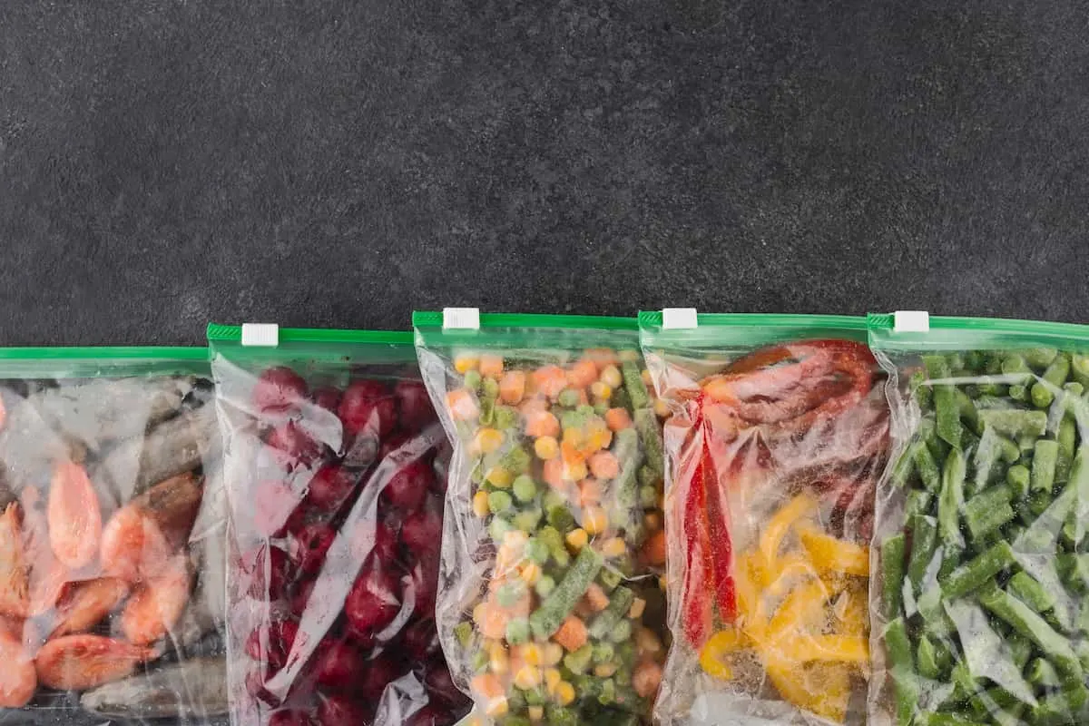 Bolsas con alimentos congelados y verduras variadas.