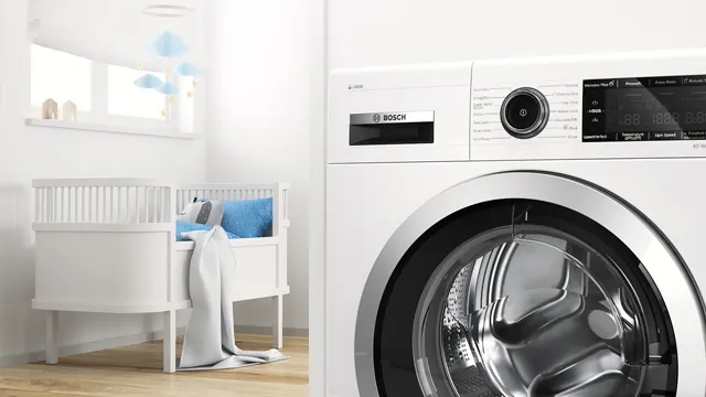 Vista de una lavadora con motor EcoSilence y, a través de una puerta abierta, una habitación con una cuna