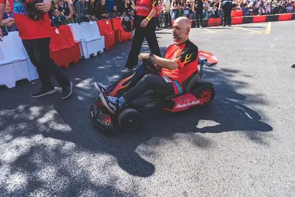 Piloto de MediaMarkt conduciendo un mini-kart eléctrico en el evento.