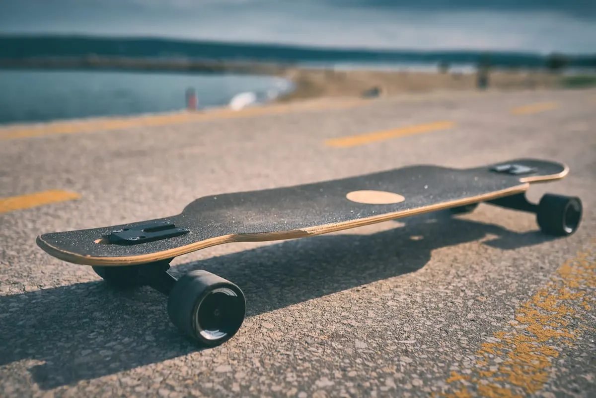 Longboard eléctrico sobre asfalto con vista al mar de fondo