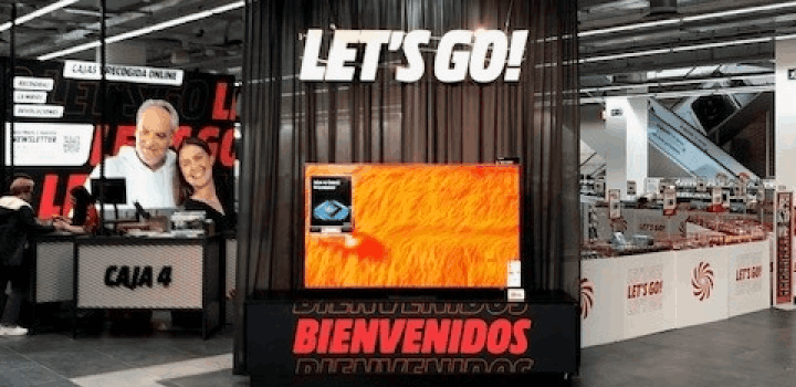Tienda con la frase "Let's Go!" en la parte superior, un televisor y un cartel de "Bienvenidos" en rojo.