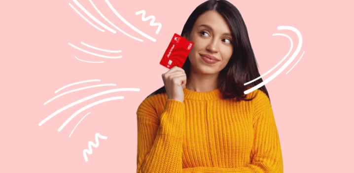 Mujer con suéter naranja sostiene una tarjeta roja frente a un fondo rosa con líneas blancas.