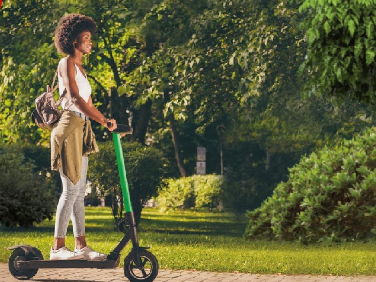 Persona usando un patinete eléctrico en un parque.
