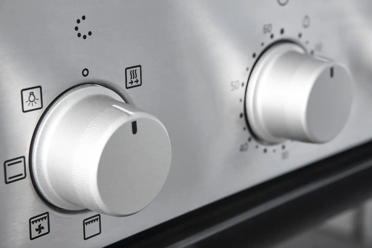Primer plano de los mandos de control de un horno de acero inoxidable