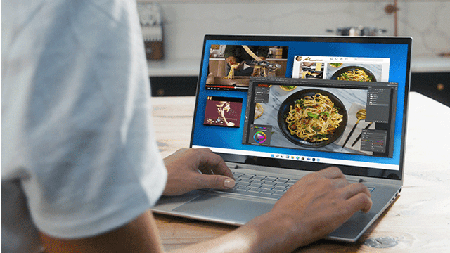 Persona usa un portátil con varios programas abiertos, incluyendo edición de vídeo y fotografía de espaguetis.