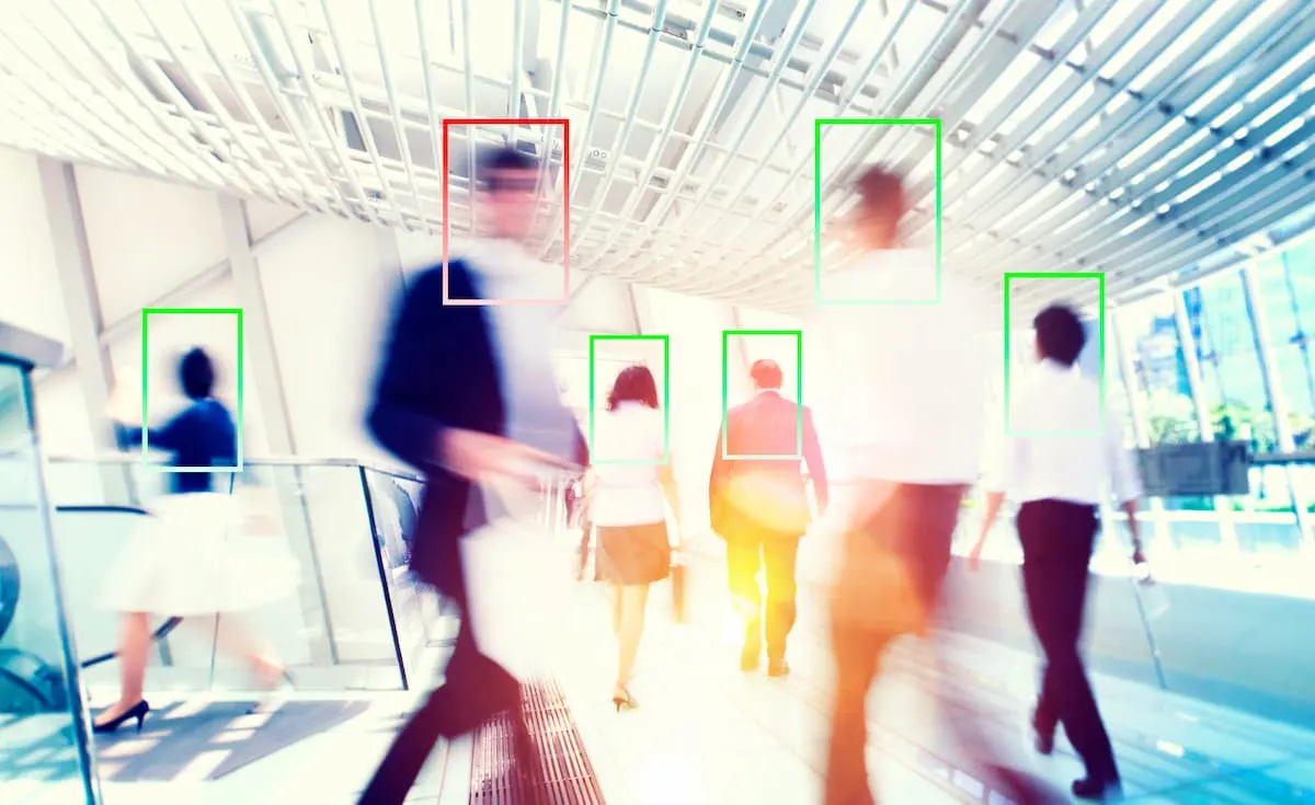 Personas caminando mientras un sistema detecta y marca sus siluetas.