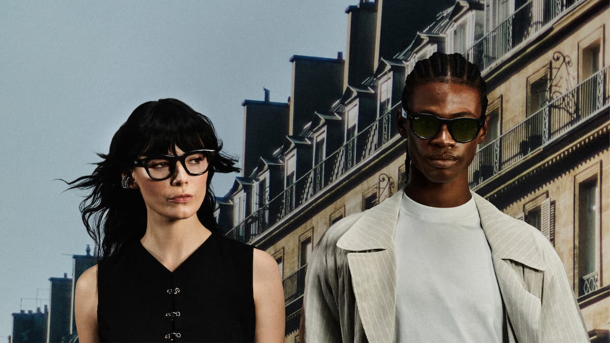 Dos personas con gafas Ray-Ban Meta con montura negra y verde frente a edificios parisinos