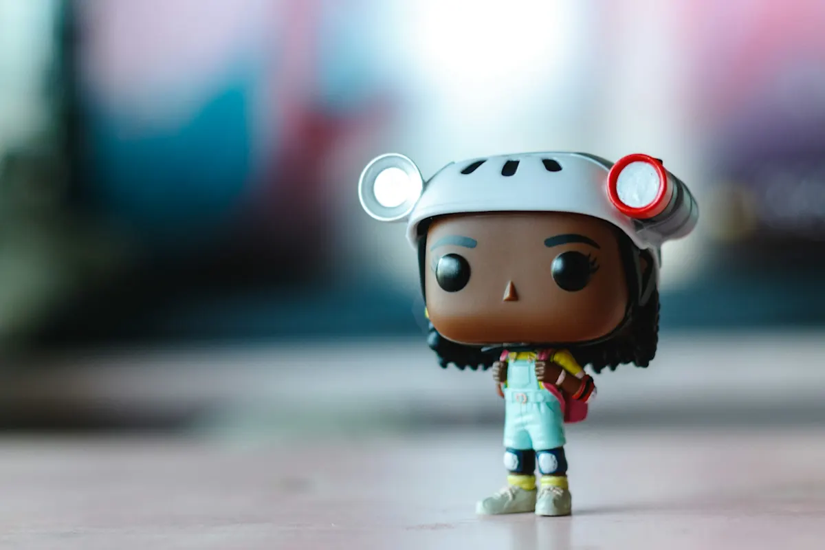 Figura Funko Pop con casco y mochila sobre fondo desenfocado.