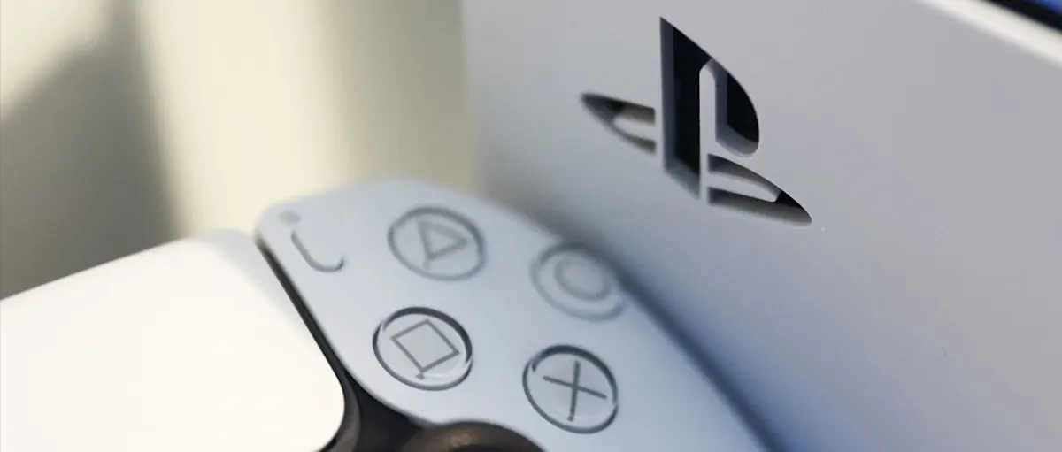 Detalle de un control DualSense junto al logo de PlayStation en la consola PS5.