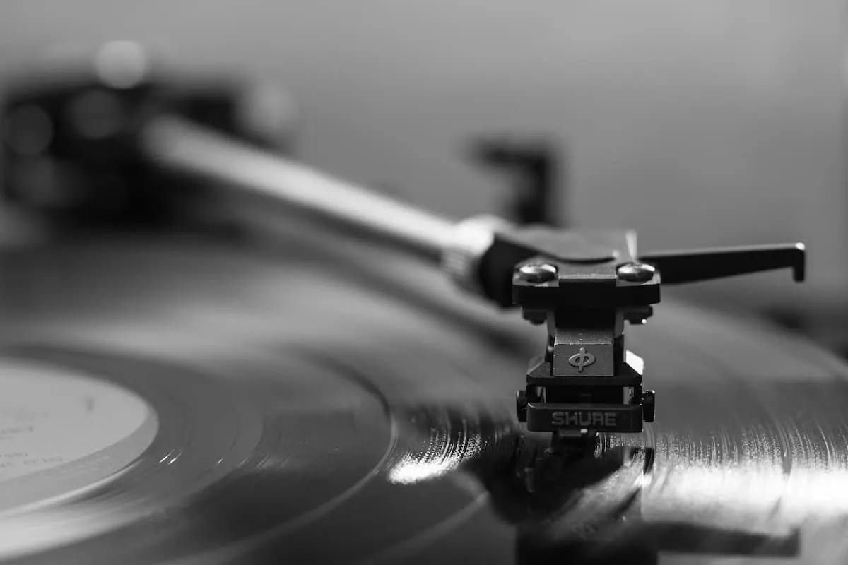 Brazo de tocadiscos reproduciendo un vinilo en blanco y negro.