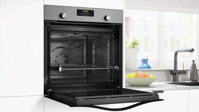 Vista lateral del horno, con la puerta abierta, mostrando las gradas cromadas y los raíles telescópicos ligeramente extraídos