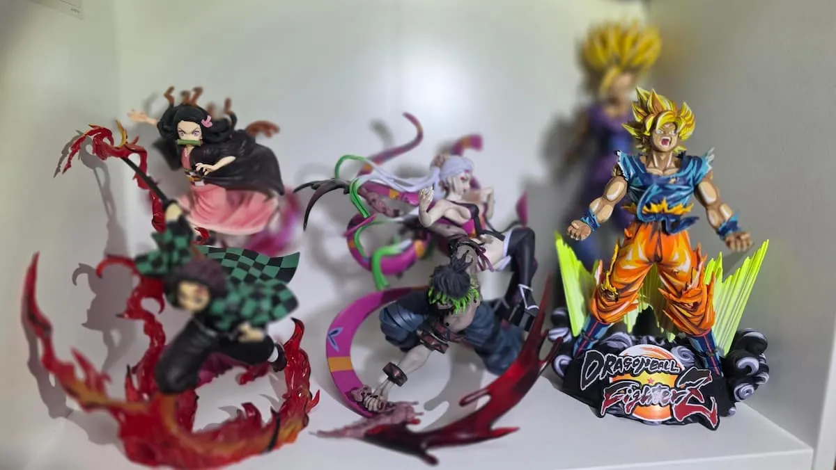 Tres figuras de anime en una estantería, incluyendo personajes de Demon Slayer y Goku Super Saiyan de Dragon Ball.