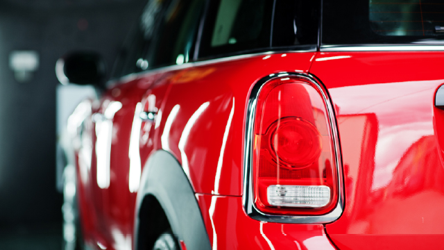 Detalle de la parte trasera de un coche rojo, con el piloto y la carrocería en primer plano. MediaMarkt by tuio.