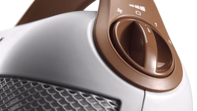 Calentador blanco con rejilla metálica y mando giratorio marrón para ajustar la configuración.