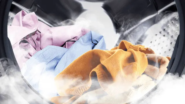 Ropa de colores dentro del tambor de la lavadora con vapor visible.