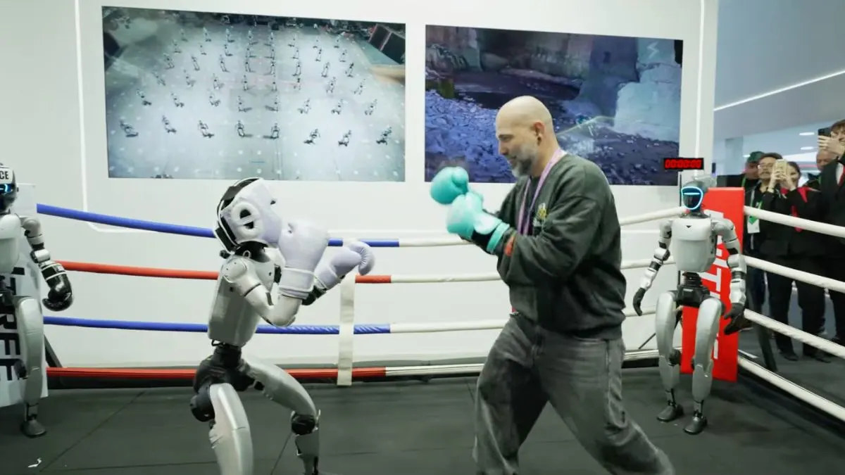 Persona boxeando con un robot humanoide en un ring de exhibición.