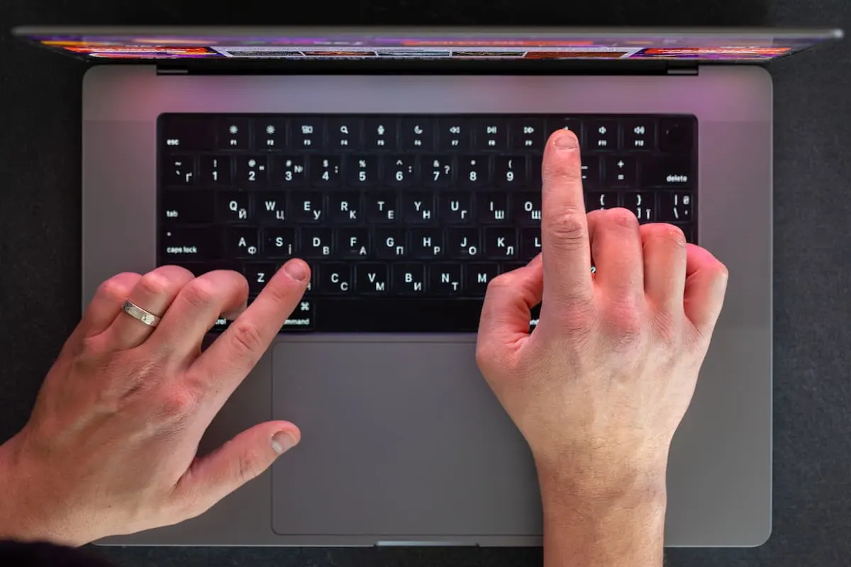 manos masculinas en el teclado del portátil con una vista superior
