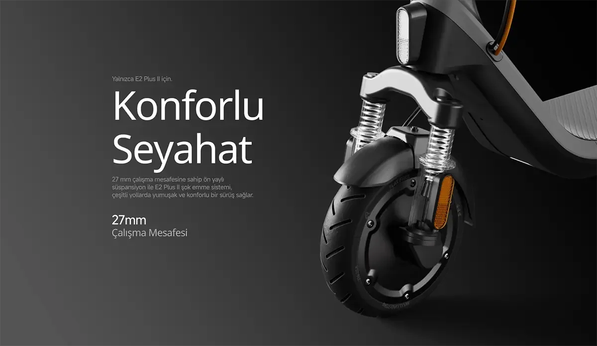 Siyah scooter'ın ön tekerleği, yaylı süspansiyonu ve ön farı yakından gösteren, teknik detaylara odaklanan bir stüdyo çekimi.