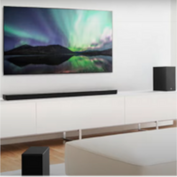 Beyaz duvarda kuzey ışıkları resmi olan TV var. Altında siyah ses çubuğu ve yanında hoparlör bulunuyor.