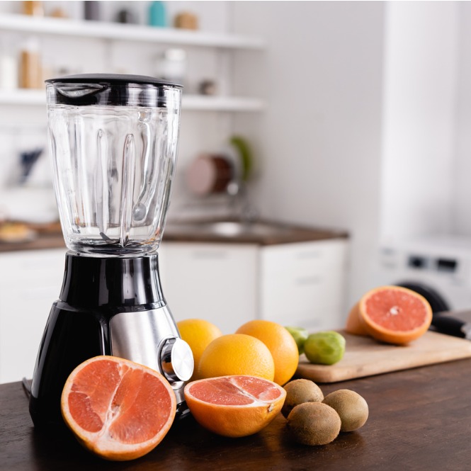 Mutfakta blender, greyfurt, portakal ve kiviler. Beyaz dolaplar arka planda.