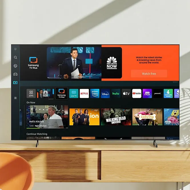 Ahşap bir dolabın üzerinde duran, akış uygulamalarıyla dolu bir Samsung TV'nin yakın çekimi.