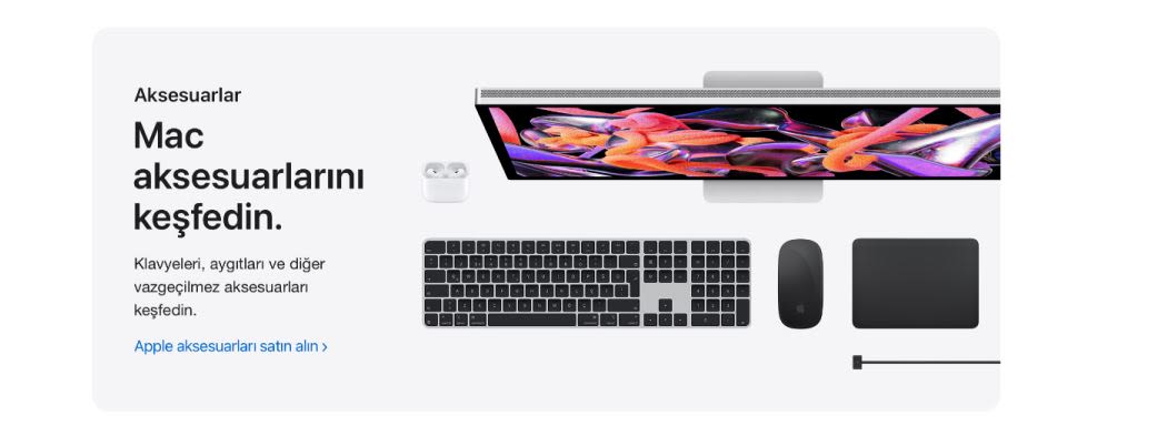 Ekran, klavye, fare, trackpad ve kulaklıkların bulunduğu beyaz bir masaüstü kurulumu.