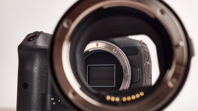 Yakın çekimde siyah bir fotoğraf makinesi objektifi ve gövdesi görülüyor. Objektif, fotoğraf makinesinin içini gösteriyor.