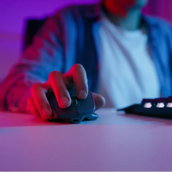 Mavi gömlekli bir kişi, mavi renkli bir fareyi tutuyor. Klavye kısmen görülebiliyor. Mor ve kırmızı renkler hakim.