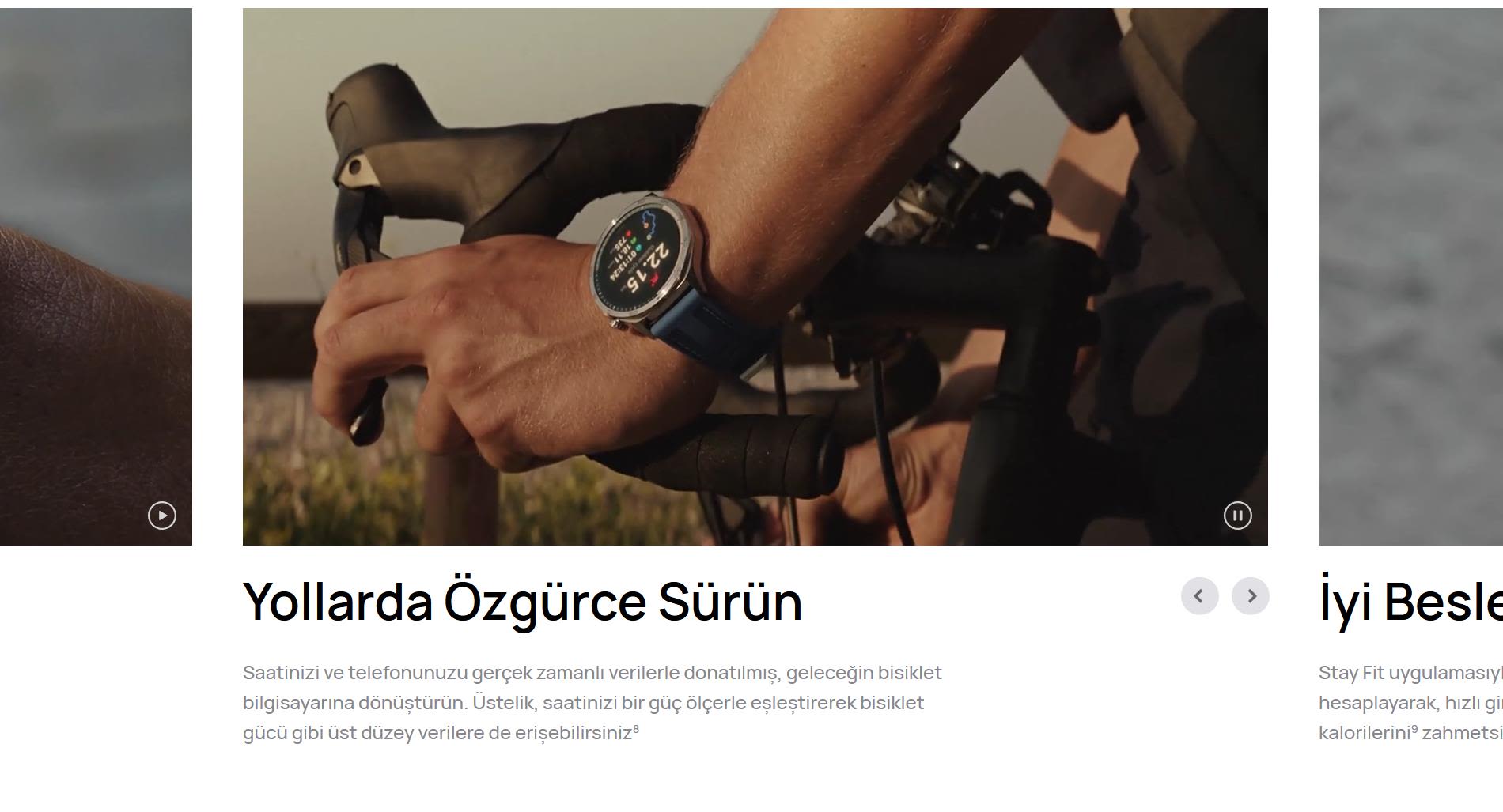 Bisiklet süren kişinin kolunda mavi kayışlı akıllı saat var. Saat ekranında 22:15 yazıyor. Arka planda yol ve bitki örtüsü görülüyor.