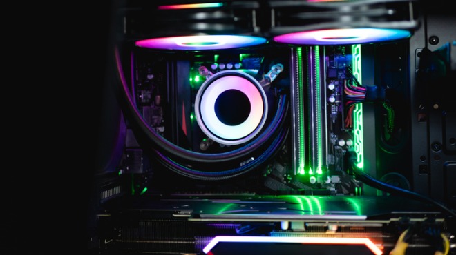 Renkli ışıklarla aydınlatılmış bir bilgisayar kasası. İçinde soğutucu, RAM ve diğer bileşenler görülüyor.